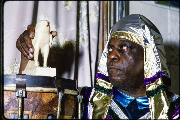 Sun Ra with a Horus sculpture inside his home in Germantown, PA, 1980 — photograph by Veryl Oakland